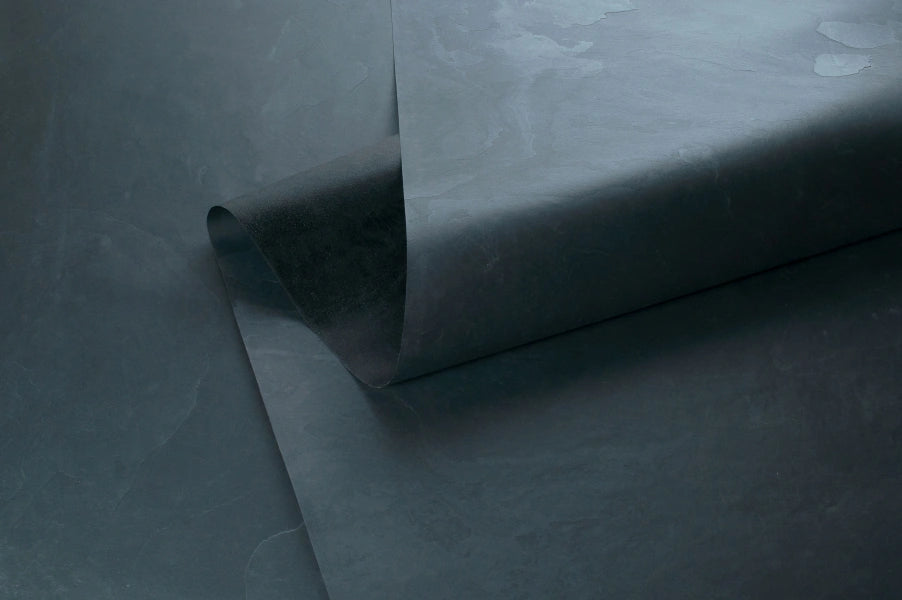 Stoneskin aus schwarzem Schiefer, hauchdünn und flexibel, zeigt die feine Struktur von Millionen Jahren geologischer Prozesse, der für die vereedelung von stonearts® Akustikpaneelen verwendet wird.